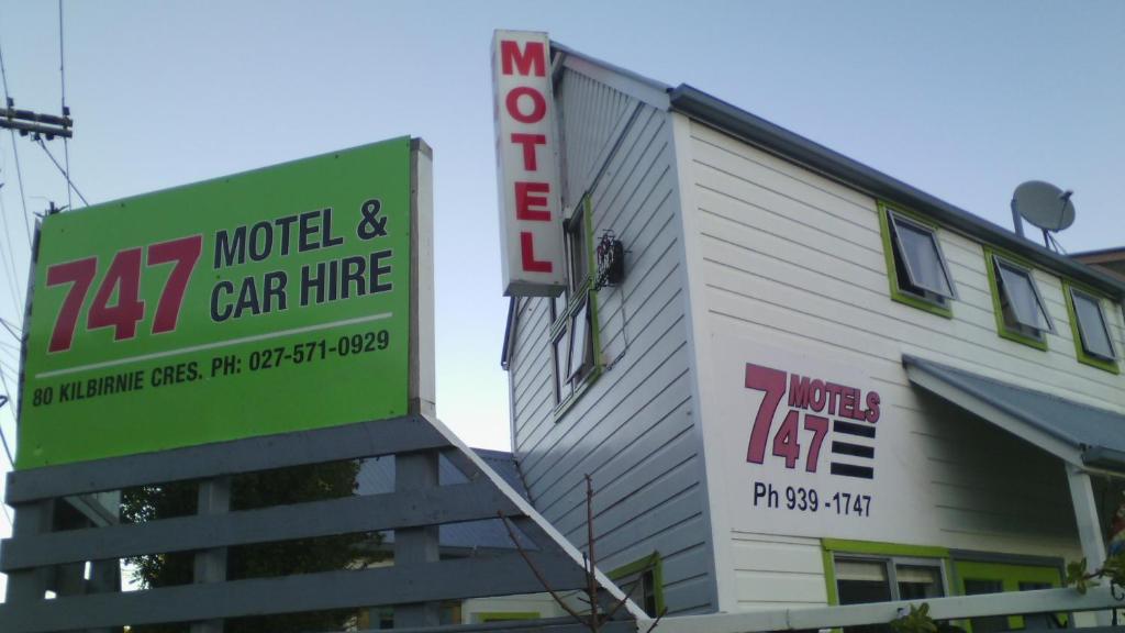 a building with a sign for a motel and car hire at Wellington 747 Motel in Wellington