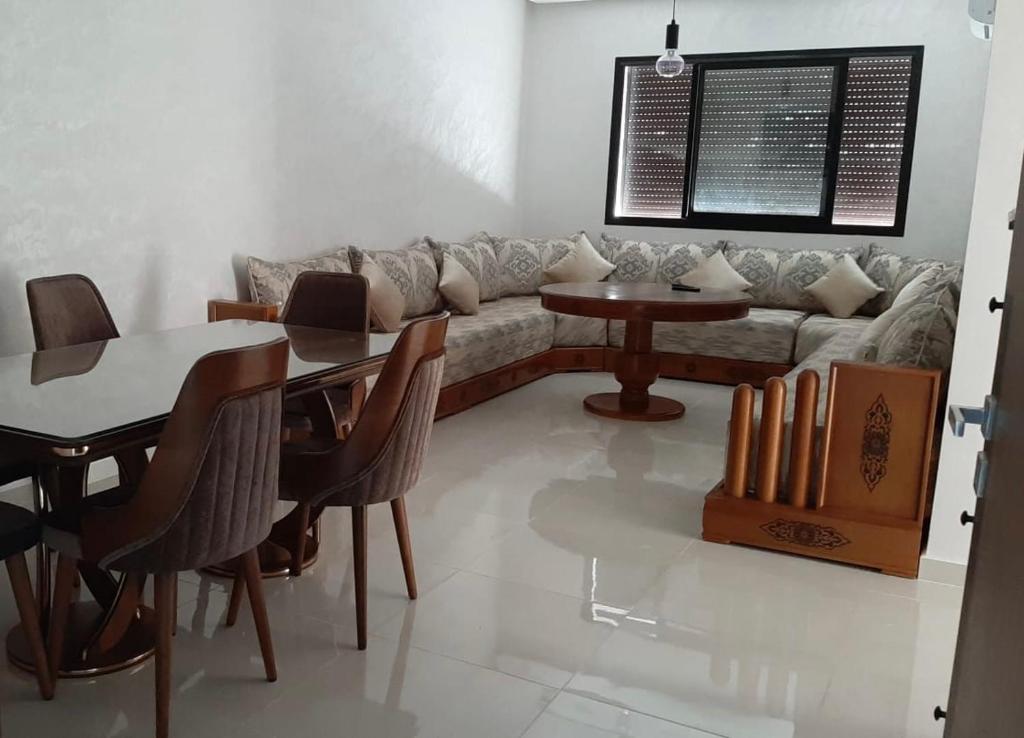 - un salon avec un canapé et une table dans l'établissement شقة مفروشة بالمسبح و نادي رياضي, à Kenitra