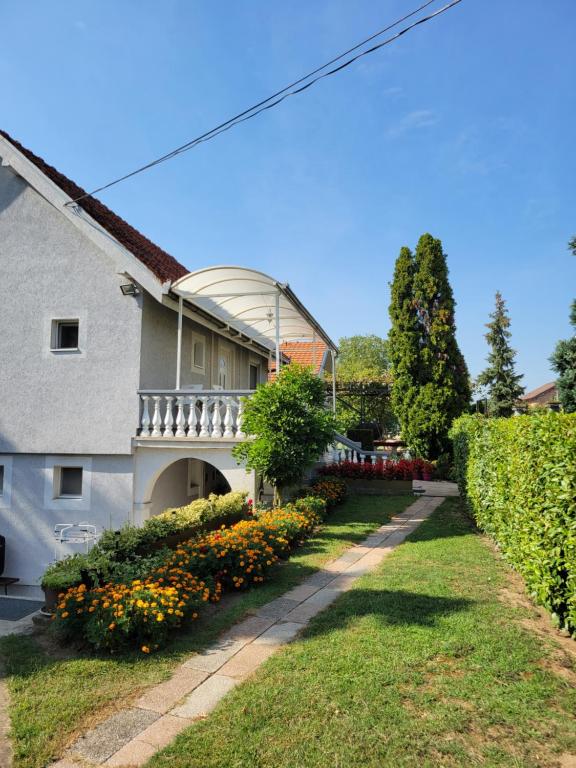 una casa con balcón y flores en un patio en Green Garden Premium en Surčin