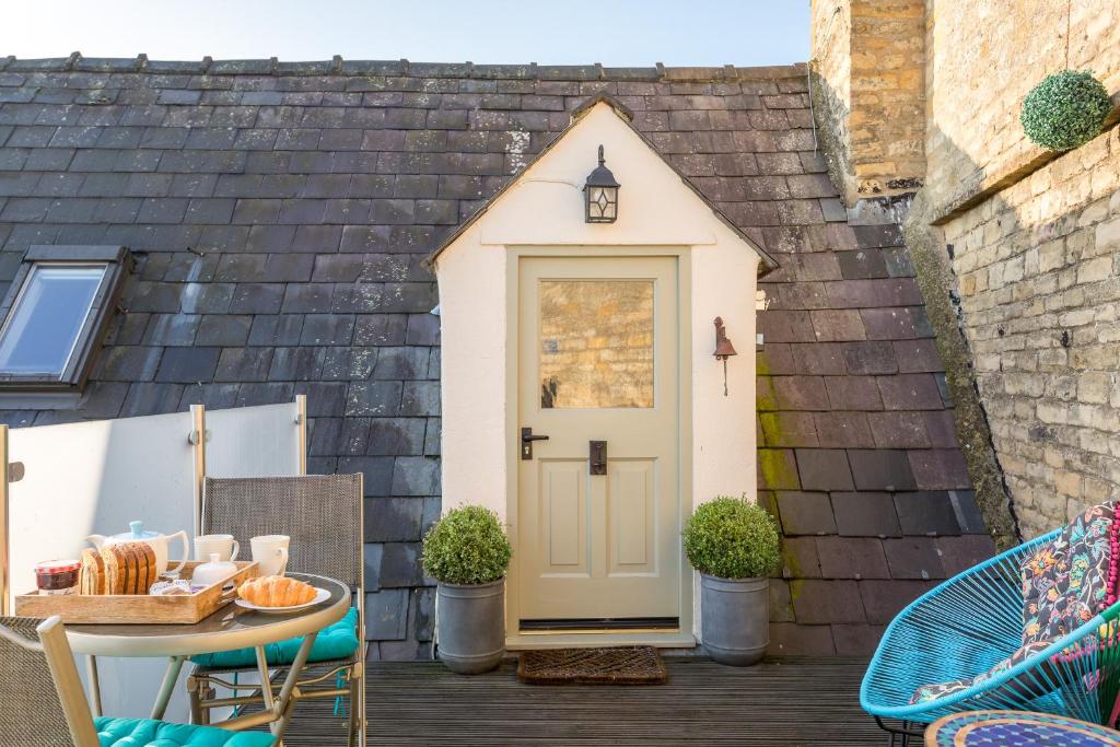 a small shed with a door on a patio at The Loft: Unique, romantic, grade II listed, dog friendly in Stow on the Wold