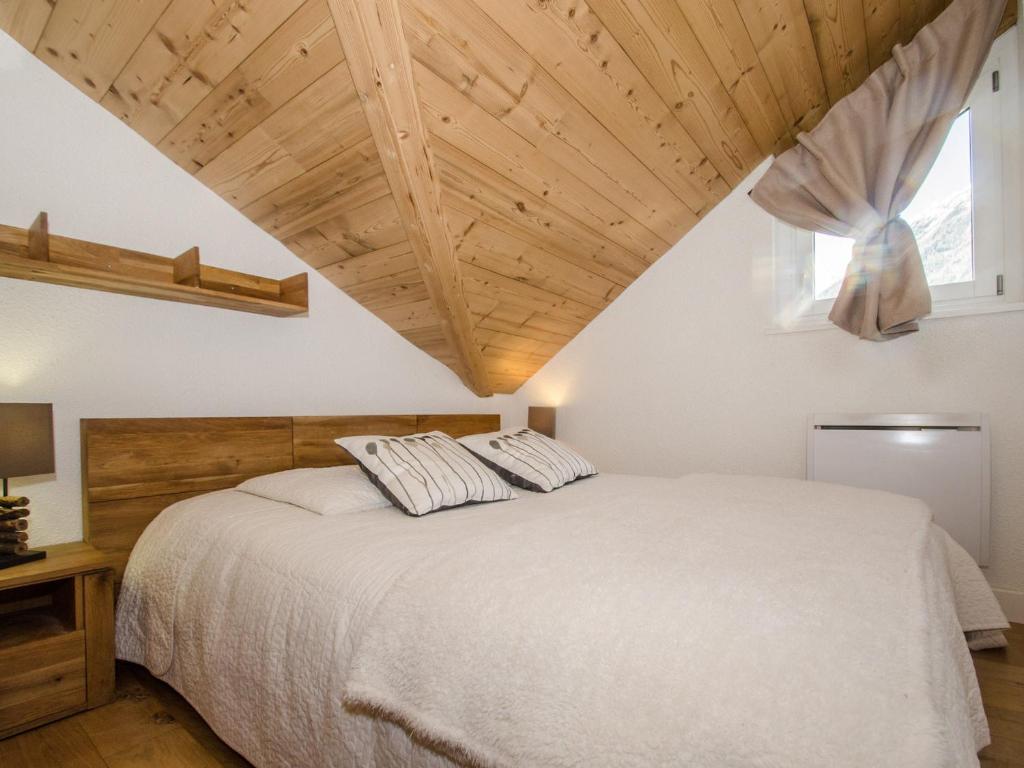 sypialnia z białym łóżkiem i drewnianym sufitem w obiekcie Appartement cosy avec balcon et WiFi à Chamonix - FR-1-343-203 w Chamonix-Mont-Blanc