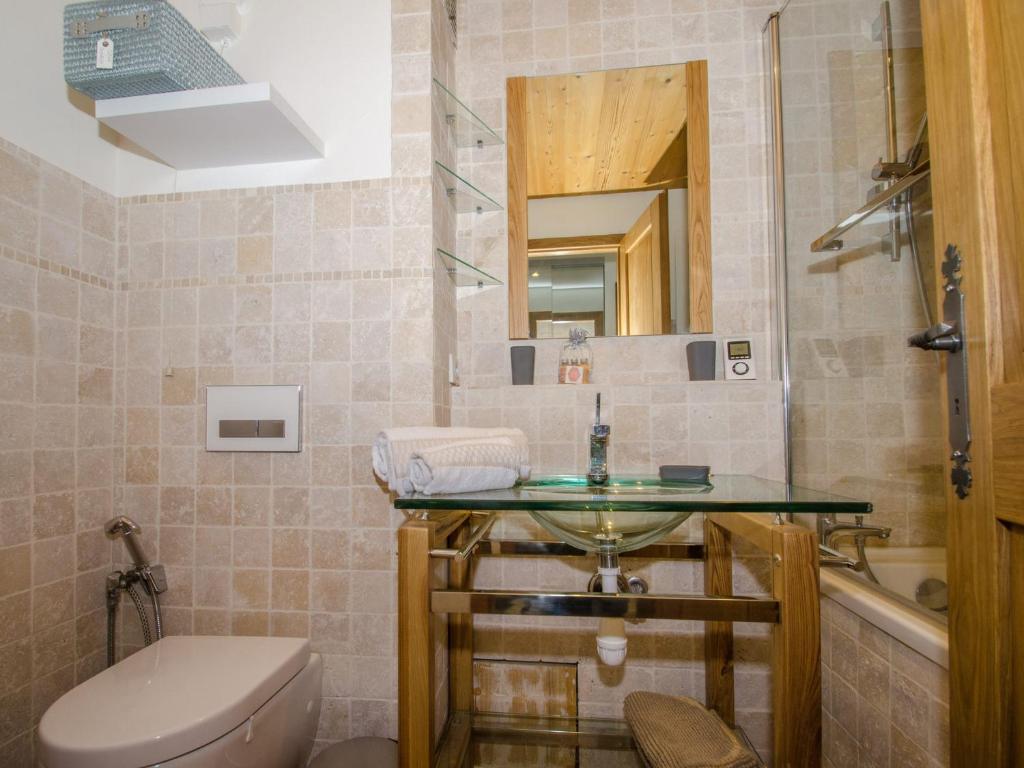 łazienka z umywalką, toaletą i lustrem w obiekcie Appartement cosy avec balcon et WiFi à Chamonix - FR-1-343-203 w Chamonix-Mont-Blanc