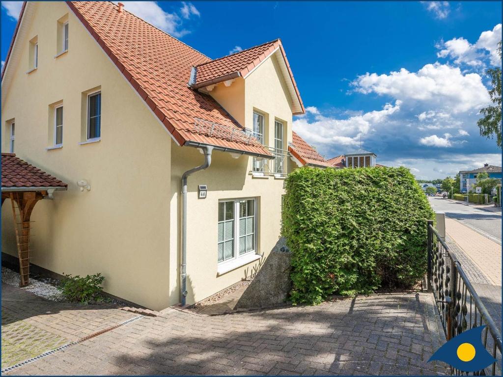 ein weißes Haus mit rotem Dach auf einer Straße in der Unterkunft Kirchstr 4a in Bansin