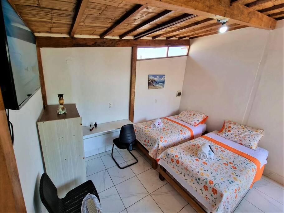 um quarto com duas camas e uma televisão em Bright Bungalow 4 - Close to ocean em Zorritos