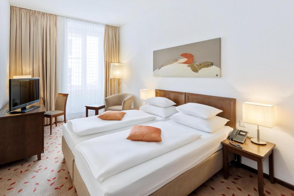 um quarto de hotel com uma cama e uma televisão em Hotel Rathauspark Wien, a member of Radisson Individuals em Viena