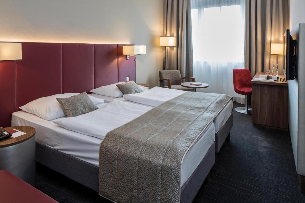 ein Hotelzimmer mit einem großen Bett in einem Zimmer in der Unterkunft Austria Trend Hotel Europa Salzburg in Salzburg