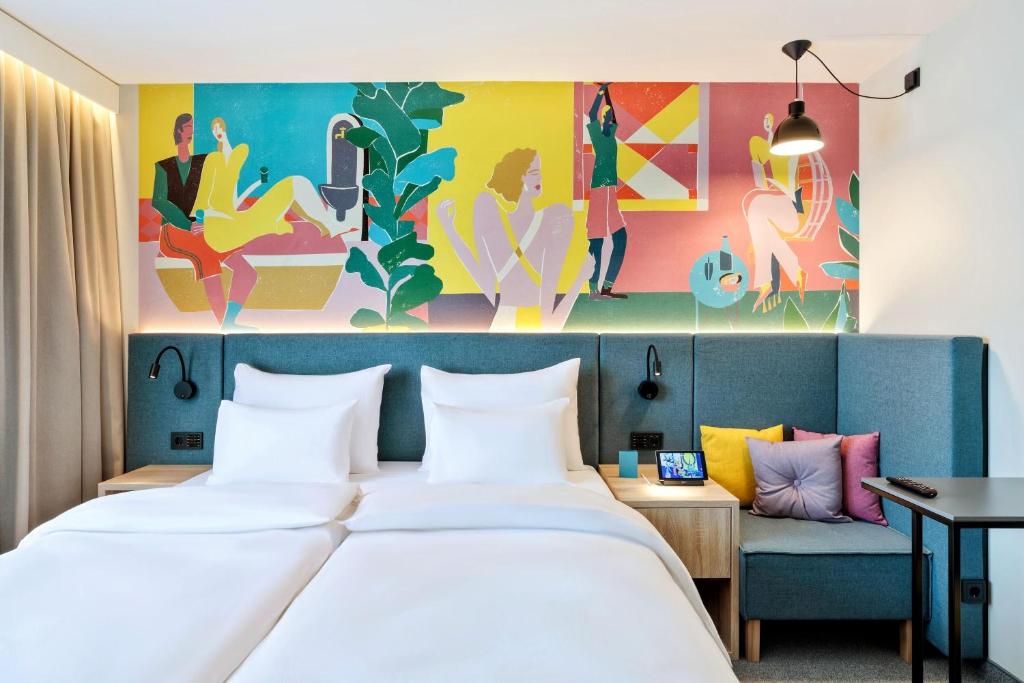 a hotel room with two beds and a colorful wall at BASSENA Wien Messe Prater in Vienna