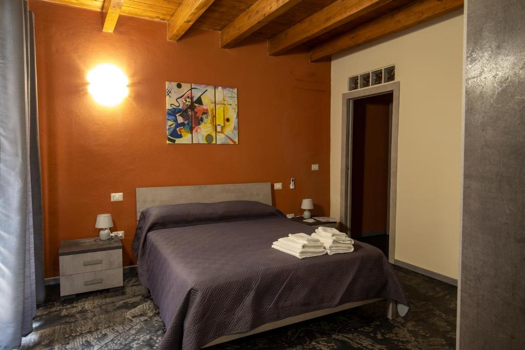 a bedroom with a bed and a painting on the wall at Via Cavour 19, Camere del Conte in Iglesias