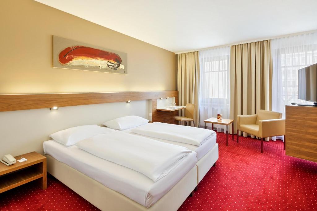 Habitación de hotel con cama y TV en Austria Trend Hotel Anatol Wien, en Viena