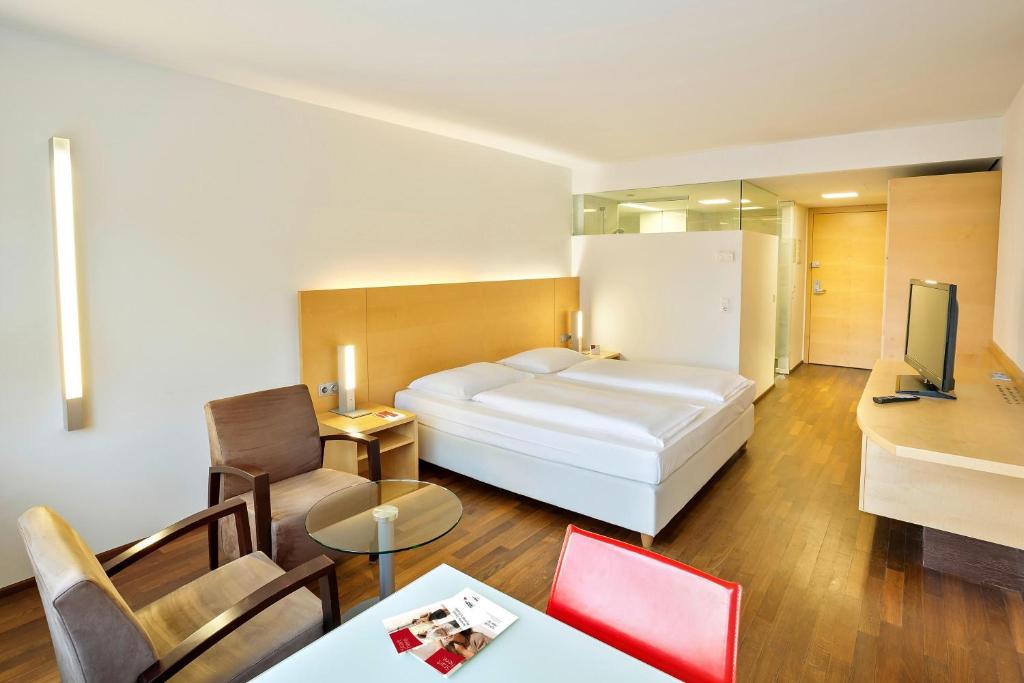 a hotel room with a bed and a living room at Austria Trend Hotel Congress Innsbruck in Innsbruck