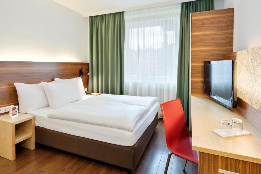 um quarto de hotel com uma cama e uma televisão em Austria Trend Hotel beim Theresianum Wien em Viena