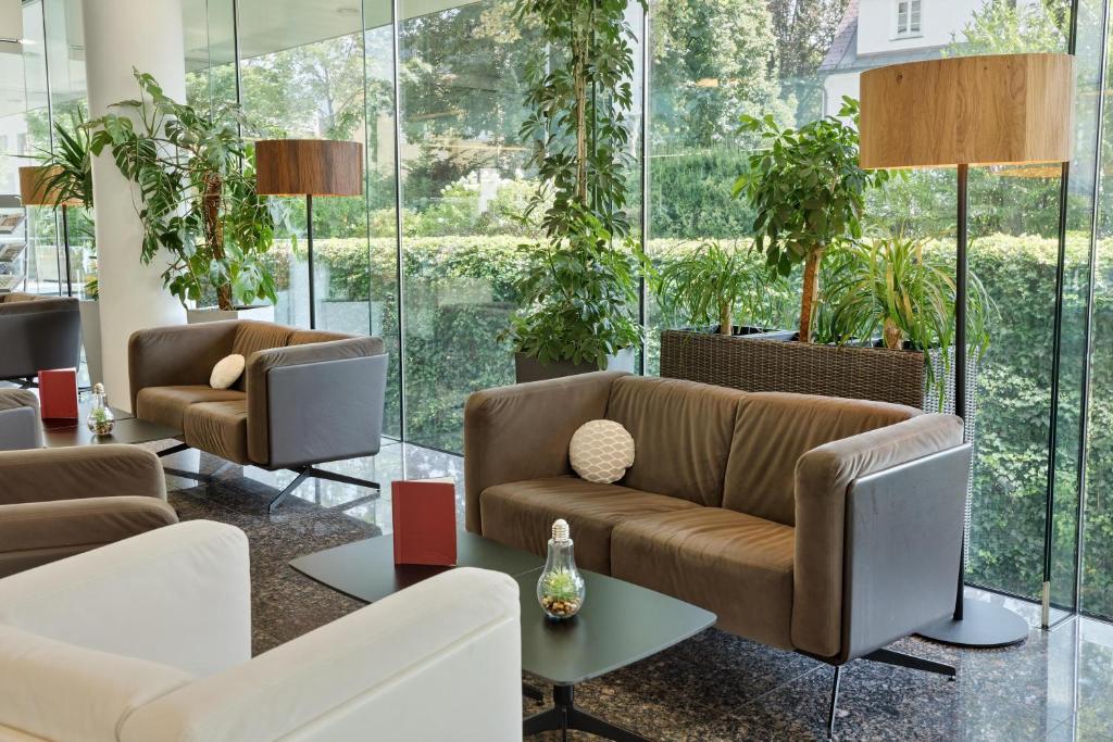 a lobby with couches and tables and windows at Austria Trend Hotel Congress Innsbruck in Innsbruck