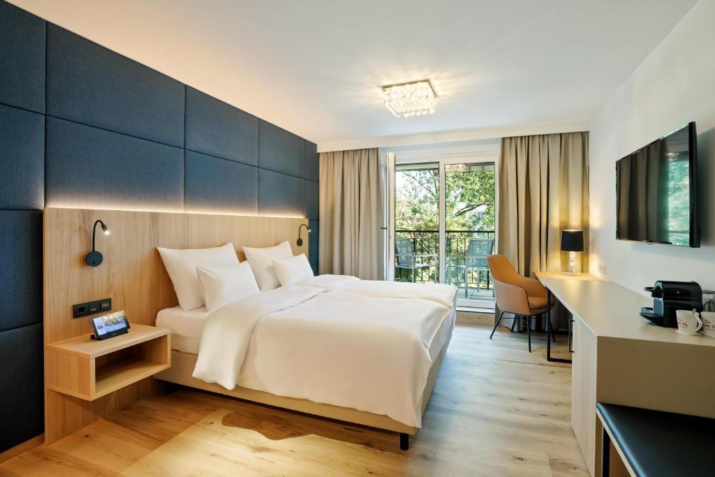 維也納的住宿－Austria Trend Hotel Maximilian，配有一张床和一张书桌的酒店客房