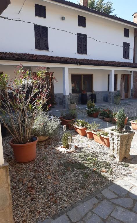 une cour avec des plantes en pot devant un bâtiment dans l'établissement La casetta di Pio, à Fresonara