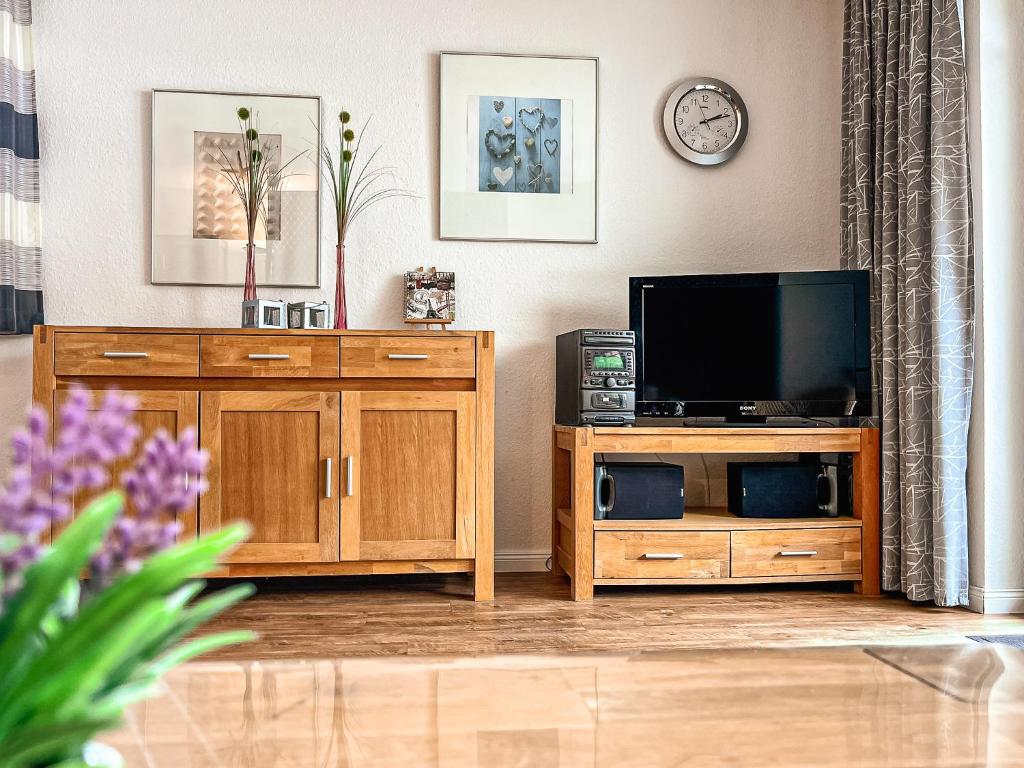 a living room with a tv and wooden furniture at Papillon Wohnung 04-1 in Boltenhagen