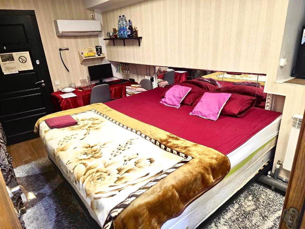 a bedroom with a large bed with red sheets at Апартаменты с трансфером in Chişinău