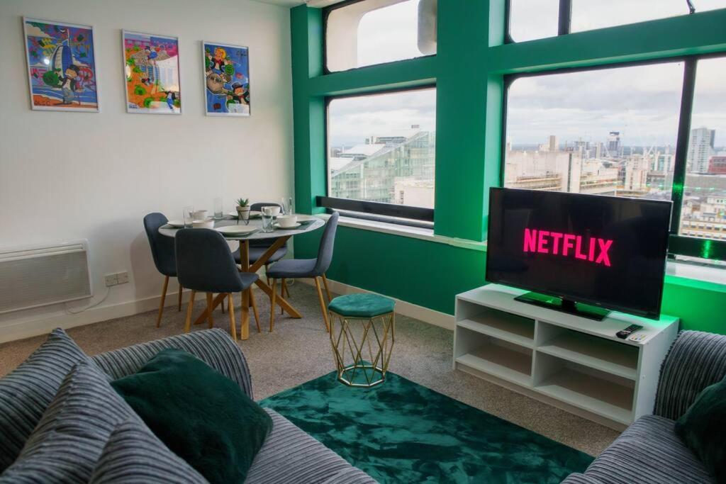 - un salon avec une télévision et une table dans l'établissement Manchester City Centre Apartment, Skyline View, à Manchester