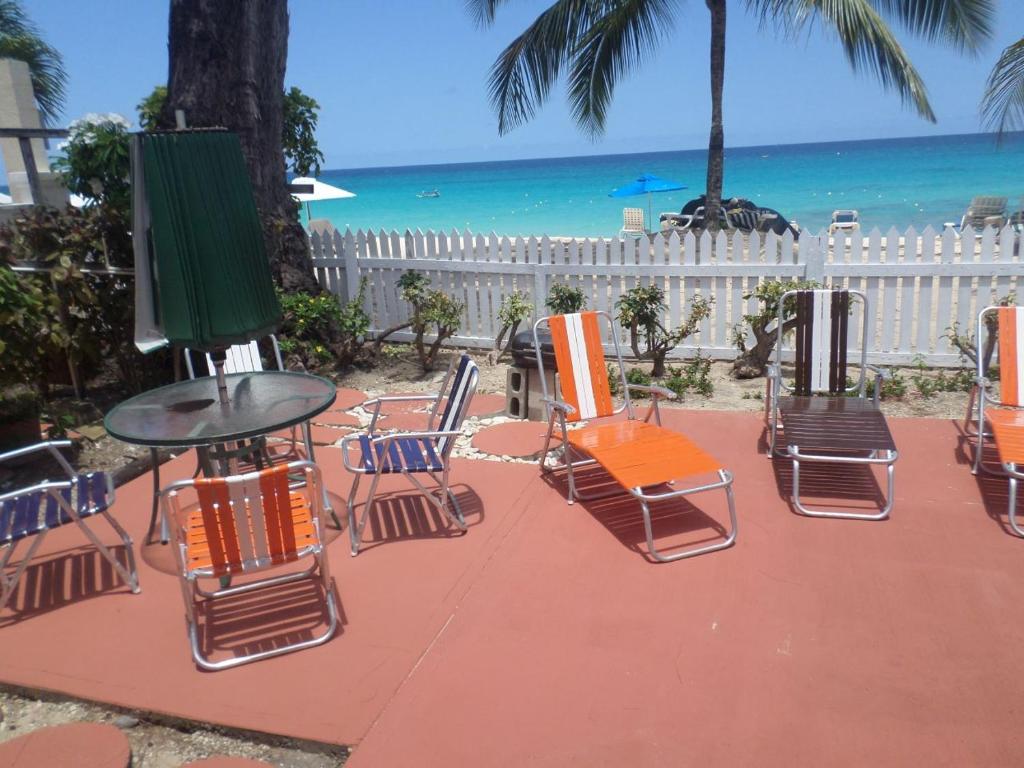 un grupo de sillas y una mesa en la playa en Annabelle's, en Saint James
