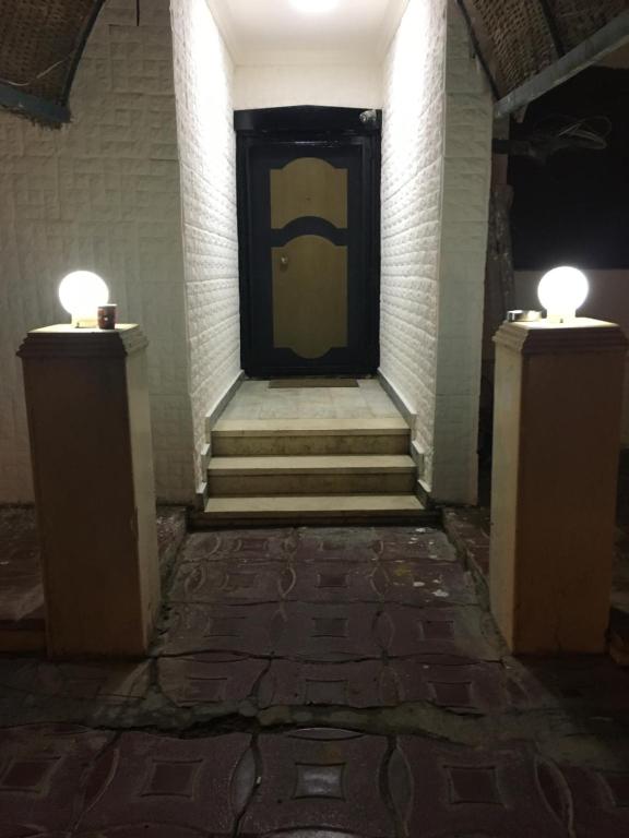 um corredor com uma porta amarela e duas luzes em Gaser resident em Cidade 6 de Outubro