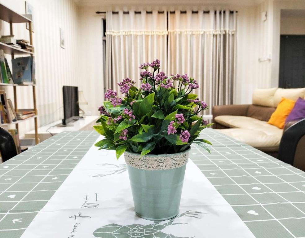 un vase rempli de fleurs violettes assises sur une table dans l'établissement JB Austin Perdana Homestay@Simple Comfy For 11pax, à Johor Bahru