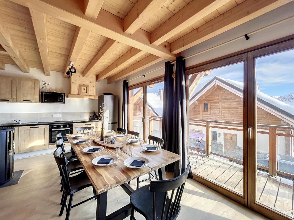 einen großen Holztisch in einer Küche mit einem großen Fenster in der Unterkunft Chalet L'Arguille in La Toussuire