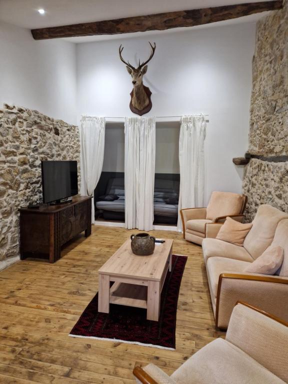 ein Wohnzimmer mit einem Sofa und einem Tisch in der Unterkunft Le Grand Cerf - 4 Couchages in Nalzen