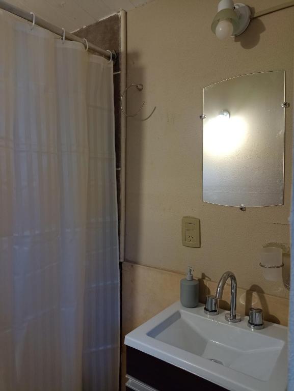 y baño con lavabo y ducha con espejo. en Tiny house Bariloche en San Carlos de Bariloche