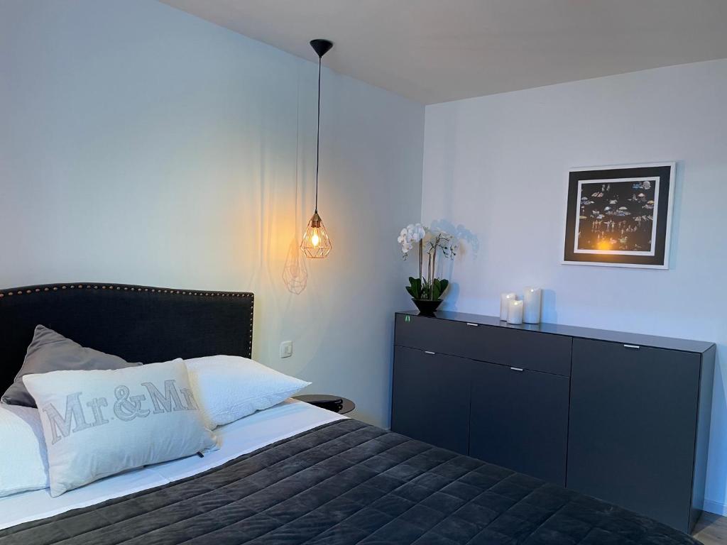 a bedroom with a black bed and a dresser with flowers at Sea View Kozino in Kožino