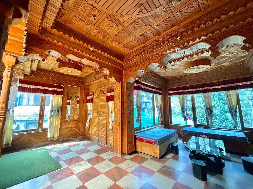 een grote kamer met een houten plafond en ramen bij One Light Stays - Kasol in Kasol