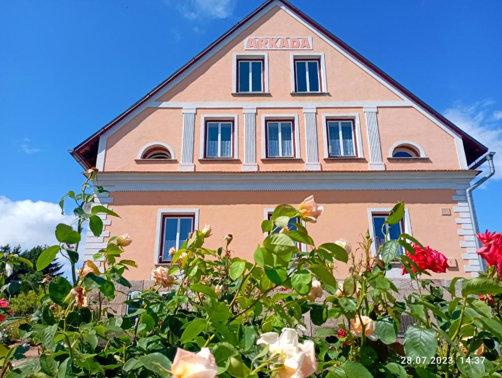 ein rosafarbenes Gebäude mit Blumen davor in der Unterkunft Chalupa-statek Arkáda in Božanov