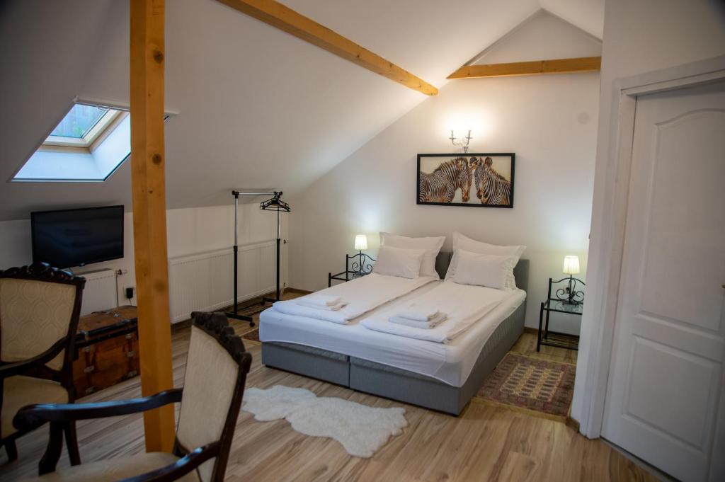 um quarto com uma cama branca e uma televisão em Apartman Centar em Sremski Karlovci