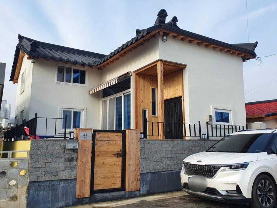 Donghae Hanok Stay في دونغ هاي: سيارة بيضاء متوقفة أمام منزل