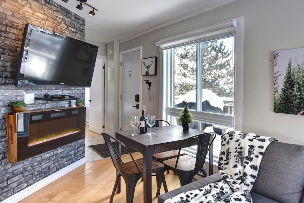 uma sala de estar com uma mesa e uma lareira em Cozy Chalet in the Mont Tremblant Ski Village em Mont-Tremblant