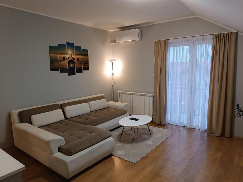 a living room with a couch and a table at Apartman Mima in Borča