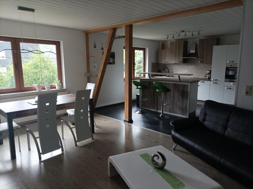 een woonkamer en een keuken met een tafel en een bank bij Ferienwohnung zur Alten Brauerei, free Wi-Fi+Parken, 3 Schlafzimmer, Grillecke in Lehesten