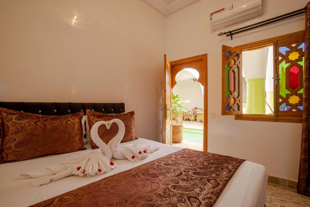 a bedroom with a bed with a heart decoration on it at Riad Petite Rose in Marrakesh
