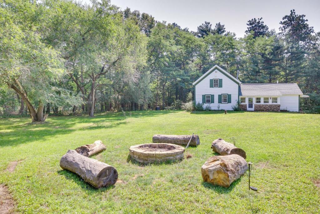 une maison avec une cour avec des bûches dans l'herbe dans l'établissement Wisconsin Cabin Getaway Near Castle Rock Late, à Mauston