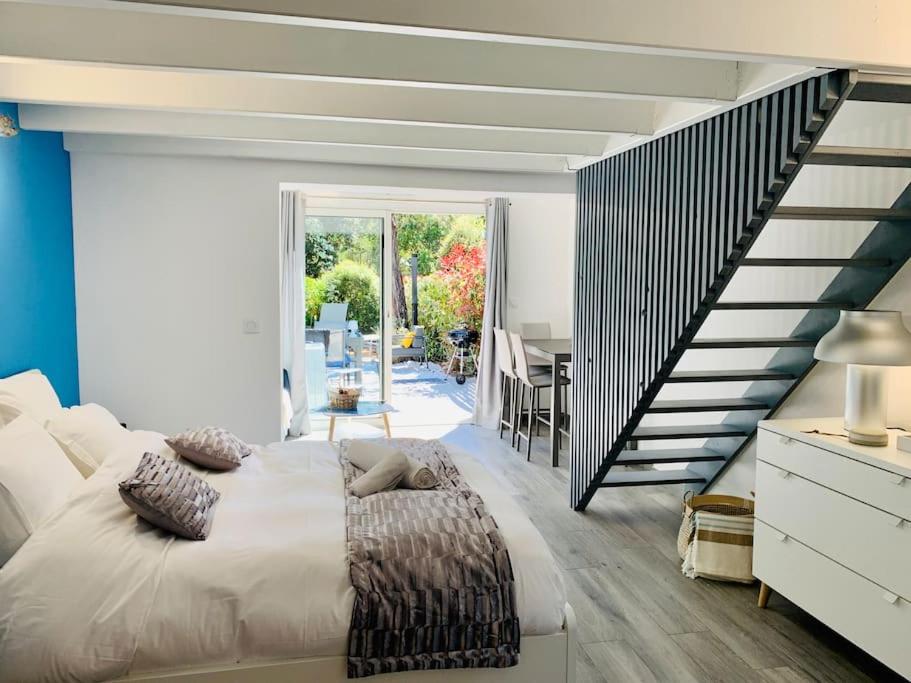 une chambre avec un grand lit et un escalier dans l'établissement Maisonnette de standing à 200m de la plage de Santa Giulia, à Porto-Vecchio