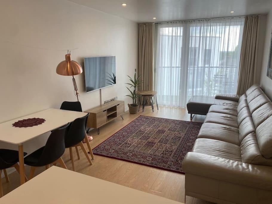 un soggiorno con divano e tavolo di Luxurious 2 bedroom flat with en-suite bedroom a South Norwood