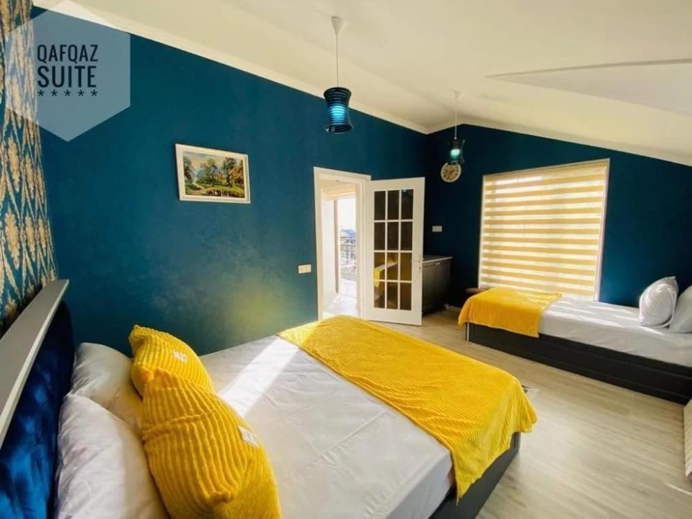 um quarto com 2 camas e uma parede azul em Qafqaz mountain white villa em Gabala