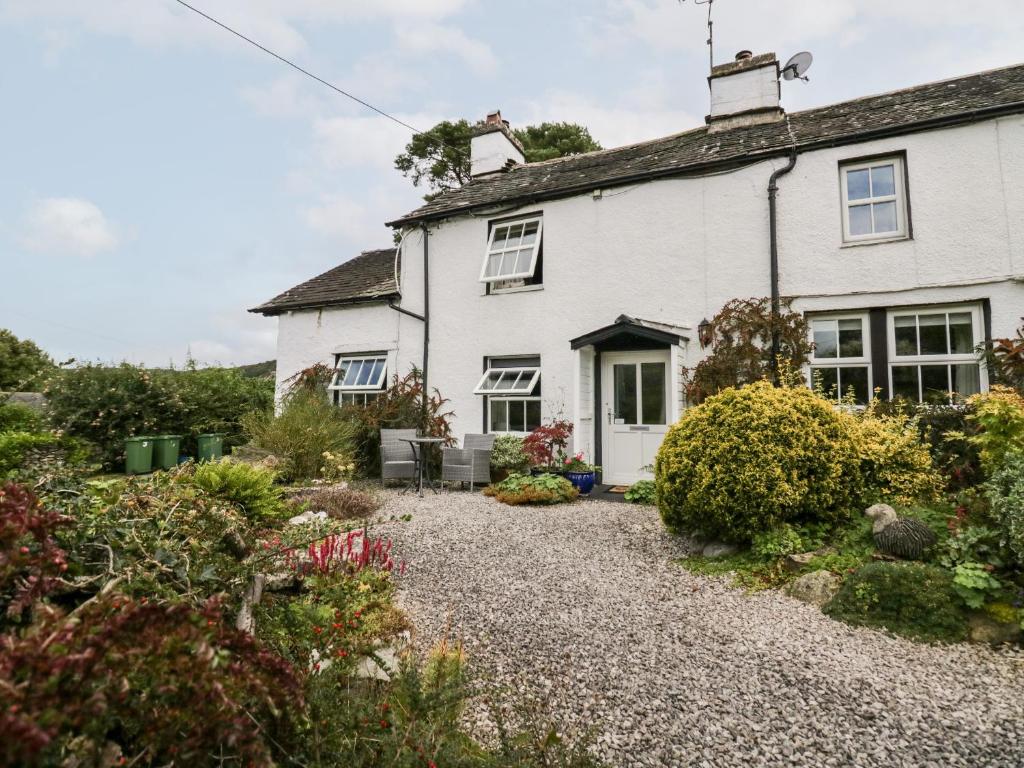 a white house with a gravel driveway at Rusland View in Ulverston