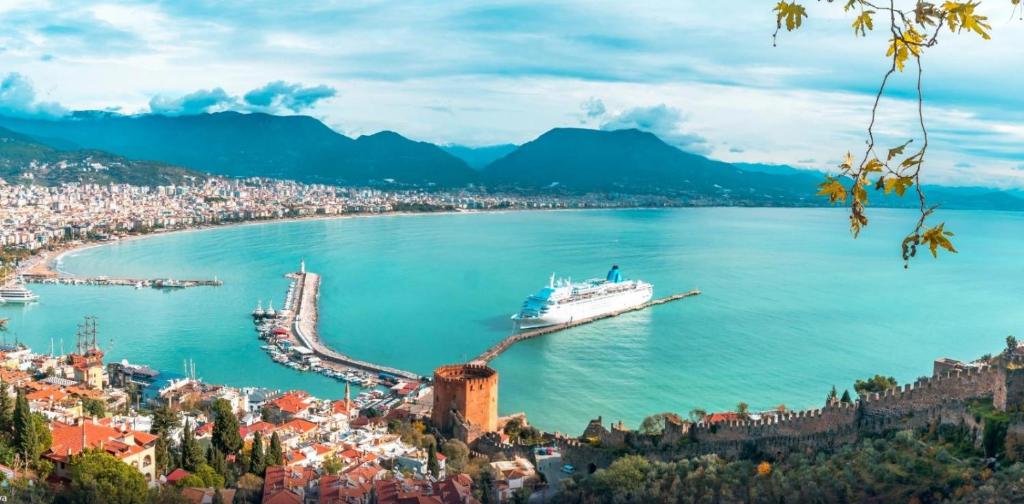 a cruise ship docked in a large body of water at A dreamy luxury two-bedroom apartment with a special view of the forest, mountains and sunset in Alanya