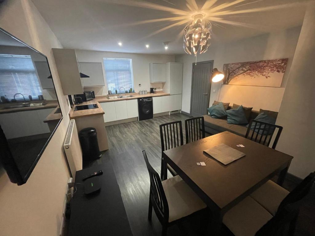 a living room and kitchen with a table and a dining room at 3 bedroom apartment in the village of Whitwell in Worksop