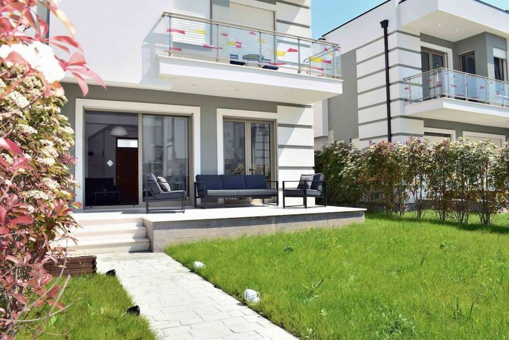 a house with a patio and a grass yard at Super Villa for vacation Gjiri i Lalzit in Draç