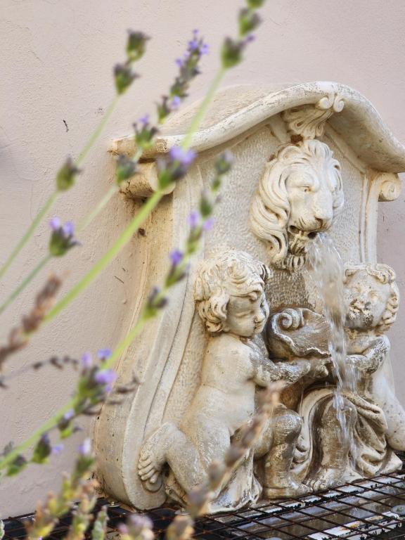 een wit standbeeld van een vrouw en een leeuw en een fontein bij La Provence Accommodation in Bloemfontein