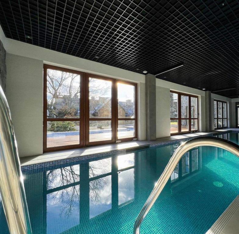 a large swimming pool with a large window in a building at Apartament ONE Szklarska Poręba in Szklarska Poręba