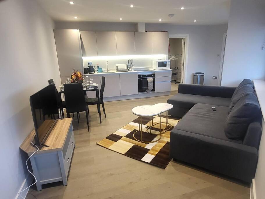 a living room with a couch and a table at Entire Reigate Apartment hosted by Pius in Reigate