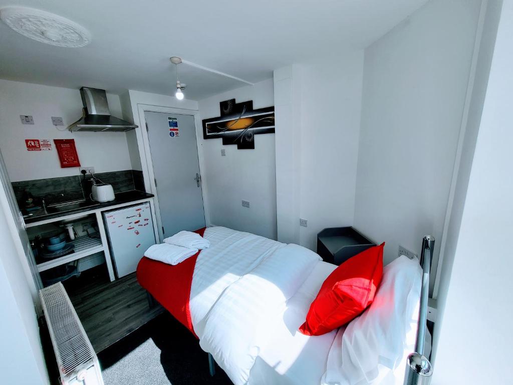Habitación pequeña con cama con almohadas rojas en Berridge Solo Stays - NG7 en Nottingham
