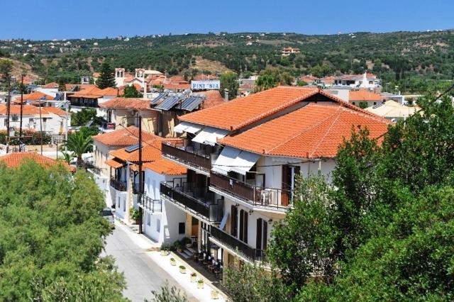 a group of houses with orange roofs in a town at Hotel Korakakis Beach in Finikounta