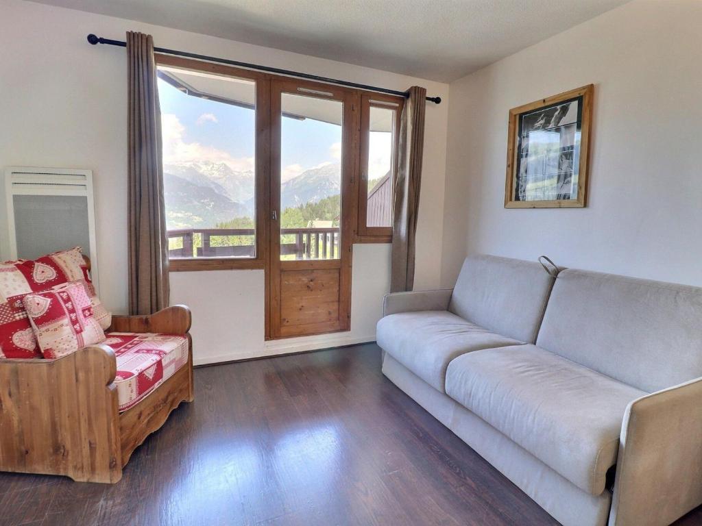 a living room with a couch and a chair and a window at Appartement La Tania, 2 pièces, 4 personnes - FR-1-182A-5 in Courchevel